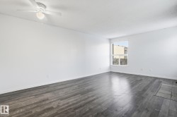 Empty room featuring dark wood finished floors, a textured ceiling, and a ceiling fan - 