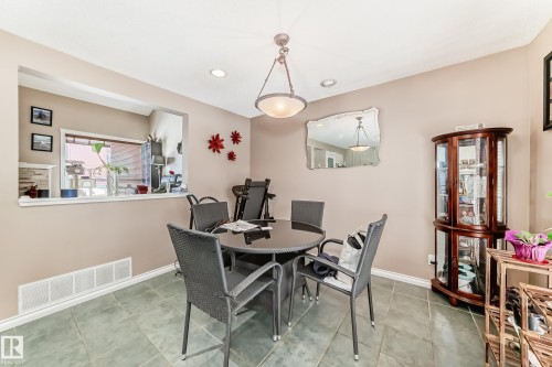 This dining area features neutral-toned walls and tiled flooring - 597 Millbourne Road E, Edmonton, AB - Indoor Photo Showing Dining Room