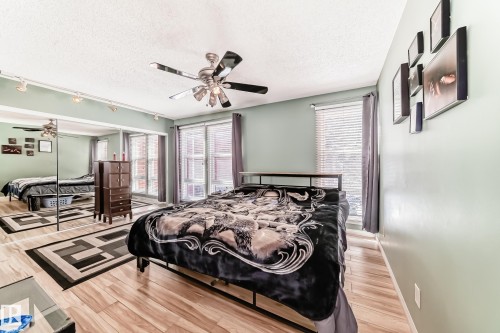This room features light-toned flooring, a ceiling fan, and track lighting - 597 Millbourne Road E, Edmonton, AB - Indoor Photo Showing Bedroom