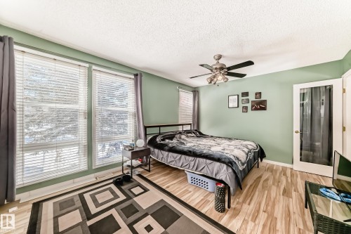 This room features light green walls, light wood-style flooring, and a ceiling fan - 597 Millbourne Road E, Edmonton, AB - Indoor Photo Showing Bedroom