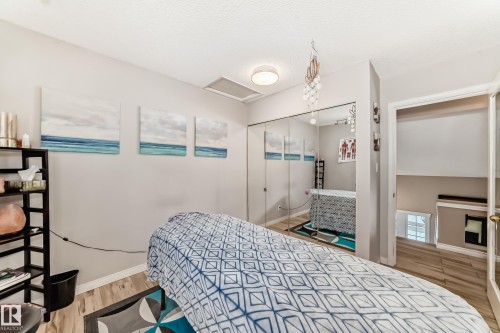 This room features light-colored walls, a ceiling light fixture, and wood-look flooring - 597 Millbourne Road E, Edmonton, AB - Indoor Photo Showing Bedroom