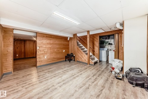 The property features wood paneling, light wood-style flooring, a staircase, and a laundry area with a washer and dryer - 597 Millbourne Road E, Edmonton, AB - Indoor
