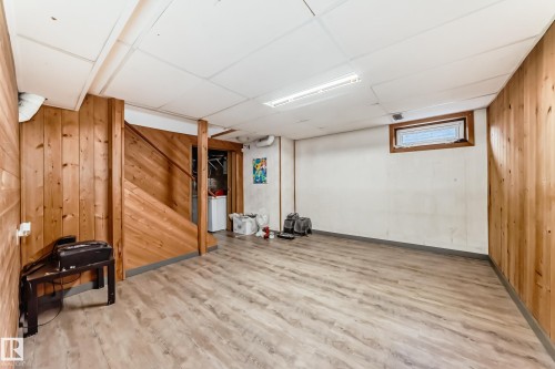 This versatile space features wood paneling, wood-look flooring, and a window - 597 Millbourne Road E, Edmonton, AB - Indoor Photo Showing Other Room