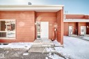 The property features a red facade with white trim, a white front door with decorative glass, and a concrete entry path - 597 Millbourne Road E, Edmonton, AB  - Outdoor 