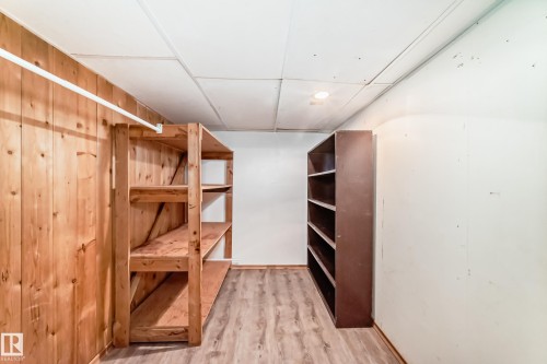 This space features wood paneling, wood flooring, and built-in shelving for storage - 597 Millbourne Road E, Edmonton, AB - Indoor Photo Showing Other Room