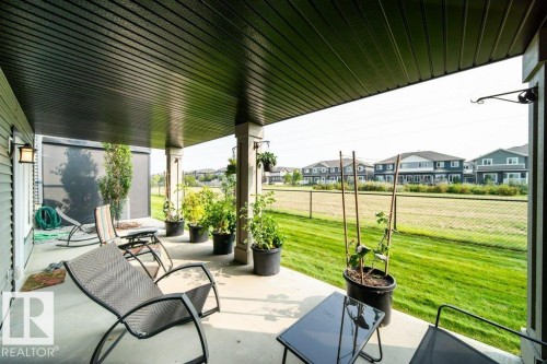 The property features a covered patio with a concrete surface, providing an outdoor living space - 3 8050 Orchards Green, Edmonton, AB - Outdoor With Deck Patio Veranda With Exterior