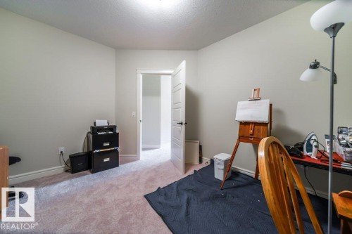 This room features neutral-toned walls, light-colored carpeting, and a white interior door - 3 8050 Orchards Green, Edmonton, AB - Indoor