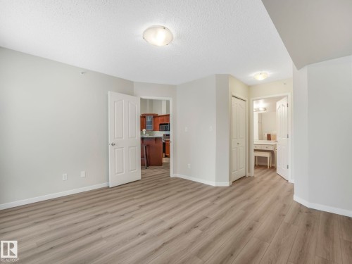 This interior space features light grey walls and light wood-style flooring throughout - 515 10311 111 Street, Edmonton, AB - Indoor Photo Showing Other Room