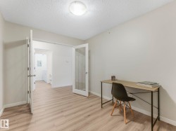 This room features light wood-look flooring, freshly-painted walls, and french doors - 