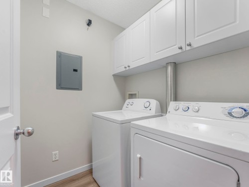 Laundry area featuring white cabinetry, a white washer, and a white dryer - 515 10311 111 Street, Edmonton, AB - Indoor Photo Showing Laundry Room