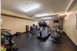 The property includes a fitness area featuring exercise equipment, a selection of free weights, and durable black flooring - 