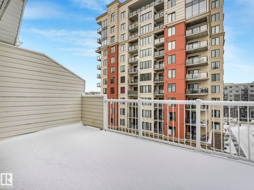 The property features a balcony with a white railing and a view of downtown buildings - 515 10311 111 Street, Edmonton, AB - Outdoor