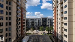 Modern high-rise residential buildings featuring private balconies with glass and metal railings - 