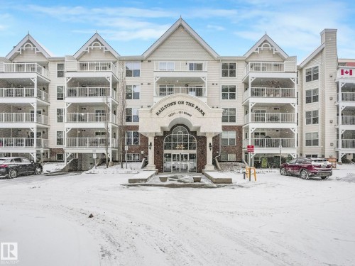 The property features a multi-story building with a light-colored facade and prominent gables - 515 10311 111 Street, Edmonton, AB - Outdoor With Facade