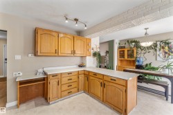 Kitchen featuring light countertops, a peninsula, and decorative light fixtures - 