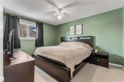 Bedroom featuring carpet floors, ceiling fan, and a textured ceiling - 