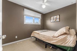 Bedroom with light carpet, ceiling fan, and a textured ceiling - 
