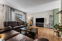 Living area with light wood-style flooring and a textured ceiling - 