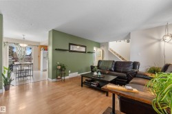 Living room with light wood finished floors, a textured ceiling, and stairway - 