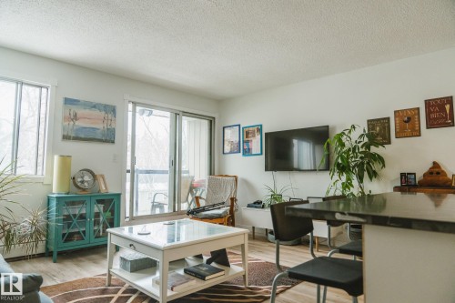 Living area featuring light wood flooring, a sliding glass door leading to an outdoor space, and white walls - 303 10432 76 Avenue, Edmonton, AB - Indoor