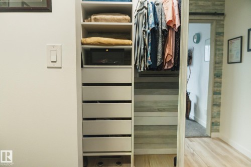 The property features a built-in closet system with open shelving and drawers, a hanging rail, and light-toned flooring - 303 10432 76 Avenue, Edmonton, AB - Indoor With Storage