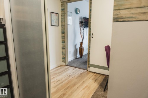 This interior space features light wood flooring and a wall with decorative paneling - 303 10432 76 Avenue, Edmonton, AB - Indoor