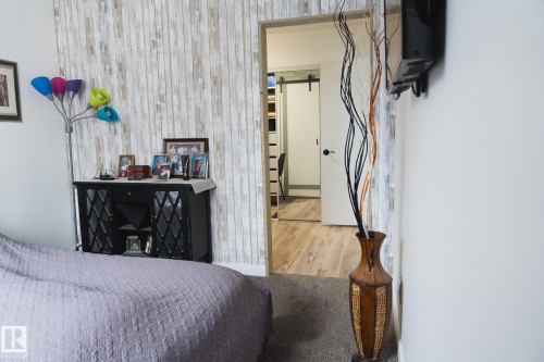 This room features a textured accent wall with a wood-look finish - 303 10432 76 Avenue, Edmonton, AB - Indoor Photo Showing Other Room