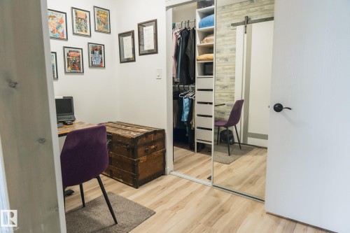 This space features light wood-style flooring and a closet with mirrored sliding doors and built-in shelving - 303 10432 76 Avenue, Edmonton, AB - Indoor