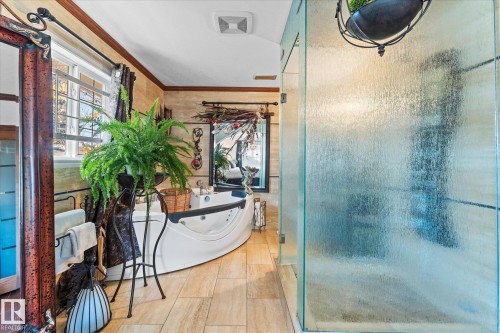 The bathroom features a spacious soaking tub, large windows providing natural light, and a separate glass-enclosed shower - 11124 110A Avenue, Edmonton, AB - Indoor Photo Showing Bathroom