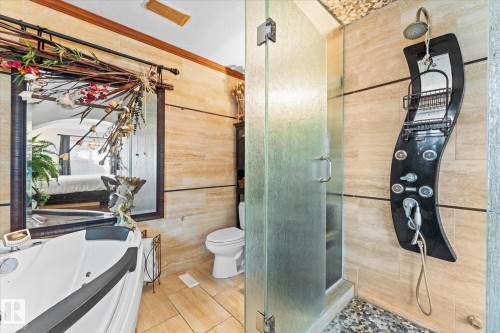 This bathroom features a jetted tub, a separate shower with a glass enclosure, and tiled walls and floors - 11124 110A Avenue, Edmonton, AB - Indoor Photo Showing Bathroom