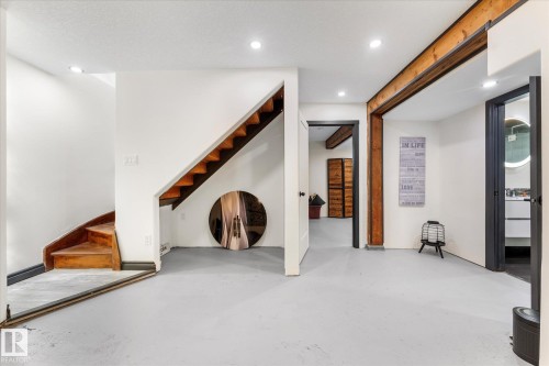 Finished space with light-colored flooring, recessed lighting, and a visible staircase with wooden treads - 11124 110A Avenue, Edmonton, AB - Indoor