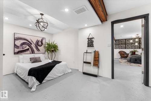 This inviting space features light-colored flooring, white walls, and recessed lighting, creating a bright atmosphere - 11124 110A Avenue, Edmonton, AB - Indoor Photo Showing Bedroom