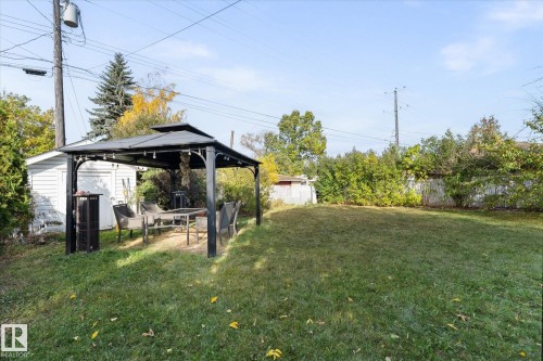 The property features a spacious lawn area, a gazebo, and a detached white shed - 11124 110A Avenue, Edmonton, AB - Outdoor