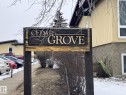 The property features a prominent wooden sign with carved lettering, set against a backdrop of light-colored siding and visible windows - 14622 118 Street, Edmonton, AB  - Outdoor 
