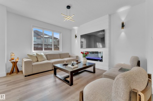Living area featuring hardwood-style flooring, an electric fireplace with a shiplap accent wall, and recessed lighting - 9 Hunter Place, Spruce Grove, AB - Indoor Photo Showing Living Room