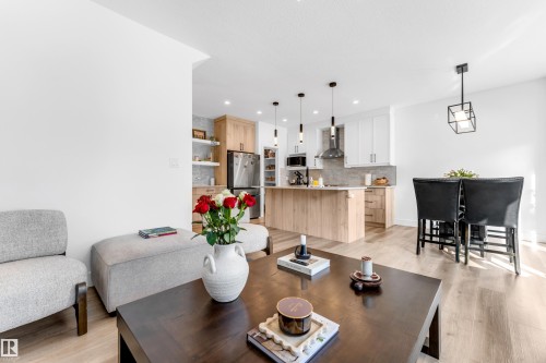 The property features an open-concept living area with light-toned flooring, a modern kitchen with light wood cabinetry, and a dining space with black high-back chairs - 9 Hunter Place, Spruce Grove, AB - Indoor
