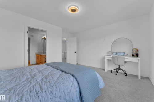 Bedroom with light gray carpeting and a contemporary ceiling light fixture - 9 Hunter Place, Spruce Grove, AB - Indoor Photo Showing Bedroom