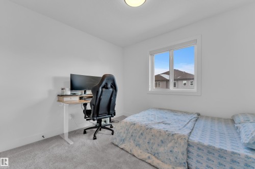 This room features light gray carpeting, neutral white walls, and a window providing natural light - 9 Hunter Place, Spruce Grove, AB - Indoor Photo Showing Bedroom