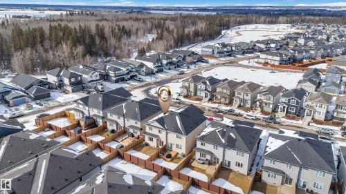 Aerial view of the property and surrounding residential neighborhood, featuring a treed area in the distance - 9 Hunter Place, Spruce Grove, AB - Outdoor With View