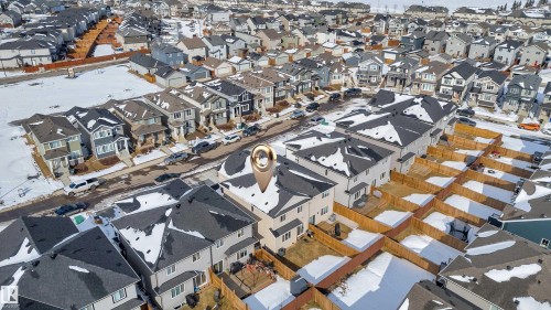 Aerial view of the property and its surrounding neighborhood, featuring a mix of residential homes with dark roofs and light-colored siding - 9 Hunter Place, Spruce Grove, AB - Outdoor With View