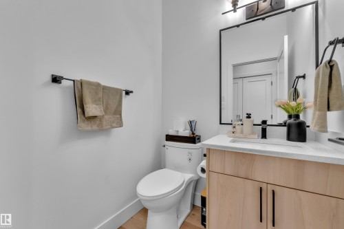 Bathroom featuring a light wood vanity with a white countertop and a contemporary black framed mirror - 9 Hunter Place, Spruce Grove, AB - Indoor Photo Showing Bathroom