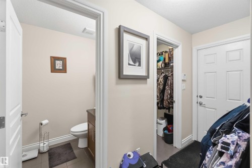 This property features a well-maintained powder room with a toilet and a vanity with a dark countertop - 2037 69A Street, Edmonton, AB - Indoor Photo Showing Bathroom