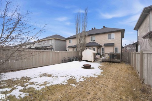 The property features a fenced yard with a deck, a storage shed, and a fire pit - 2037 69A Street, Edmonton, AB - Outdoor
