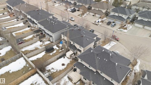 Aerial view showcasing the property's exterior, including a fenced yard, and the surrounding neighborhood with residential streets and detached homes - 2037 69A Street, Edmonton, AB - 