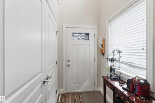 Entryway featuring a white door with decorative glass, a window with blinds, and white paneled doors - 2037 69A Street, Edmonton, AB - Indoor Photo Showing Other Room