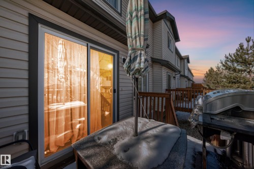 Property features a spacious outdoor deck with wooden railings and a sliding glass door entry - 23 445 Brintnell Boulevard Nw, Edmonton, AB - Outdoor With Exterior