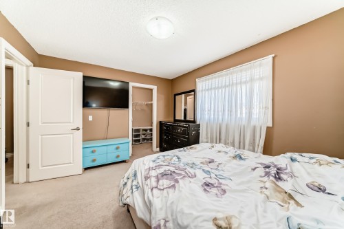 This room features carpeted flooring, a window with blinds, and doors - 23 445 Brintnell Boulevard Nw, Edmonton, AB - Indoor Photo Showing Bedroom