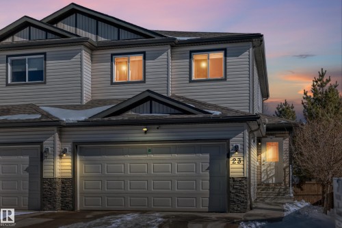 The property features a two-story exterior with light-colored siding, a dark roof, and stone facade accents - 23 445 Brintnell Boulevard Nw, Edmonton, AB - Outdoor