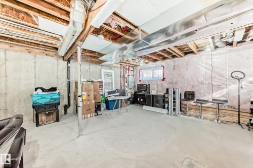 Unfinished basement with exposed wooden joists, concrete foundation walls, and a window - 23 445 Brintnell Boulevard Nw, Edmonton, AB - Indoor Photo Showing Basement
