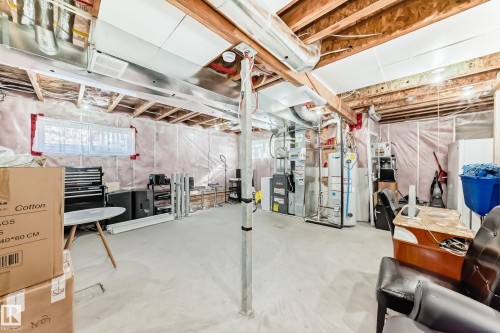 The unfinished basement offers an expansive open area, exposed ceiling beams, and a window providing natural light - 23 445 Brintnell Boulevard Nw, Edmonton, AB - Indoor Photo Showing Basement